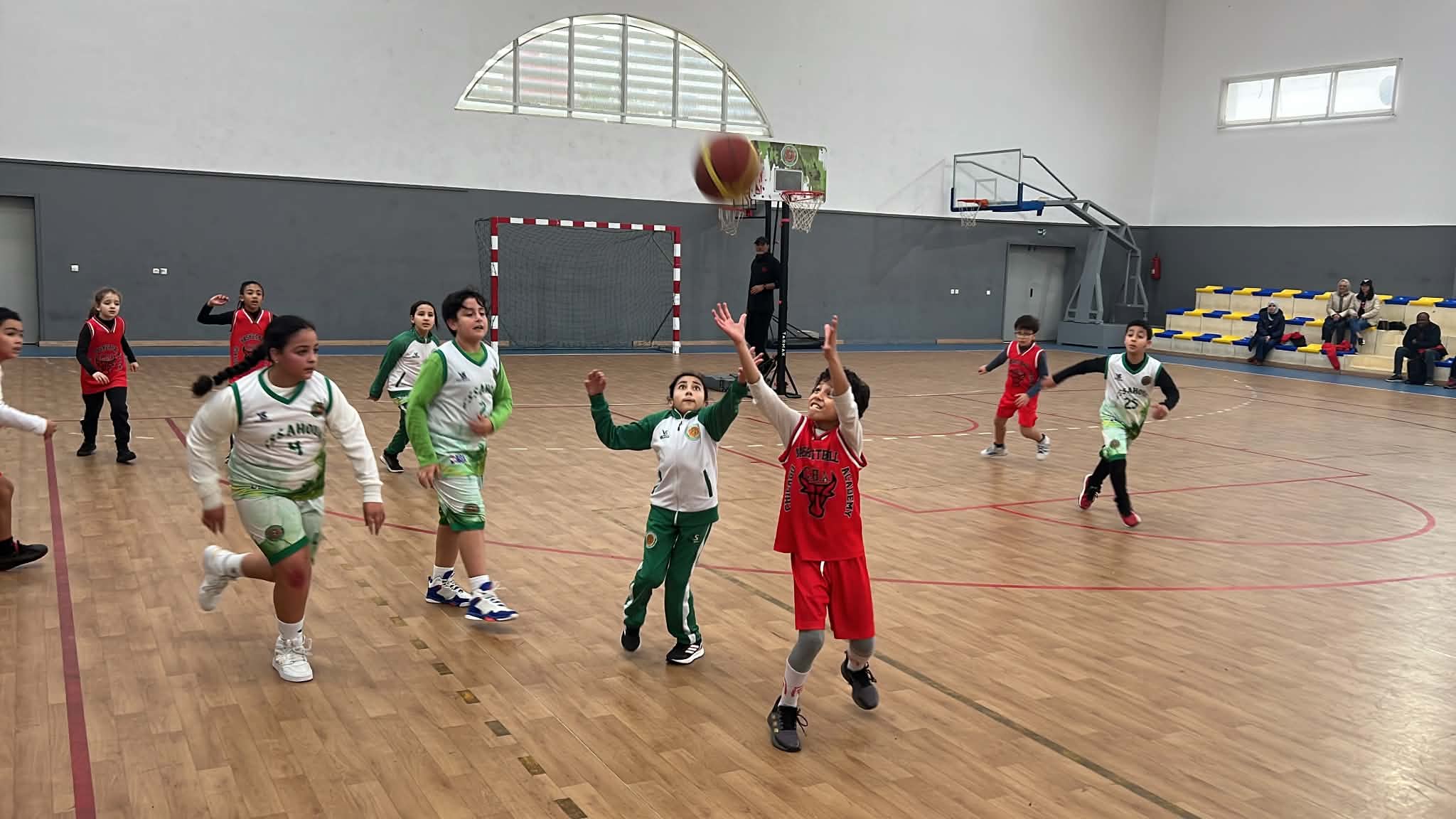 Jeunes joueurs disputant un ballon en plein match dans la salle couverte