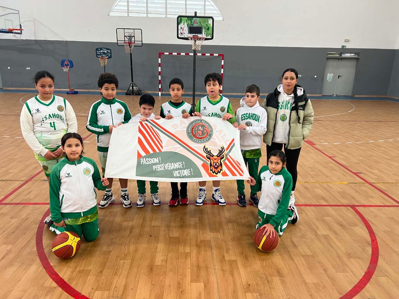 Enfants du club Essahoua Kids brandissant fièrement la banderole dans le gymnase