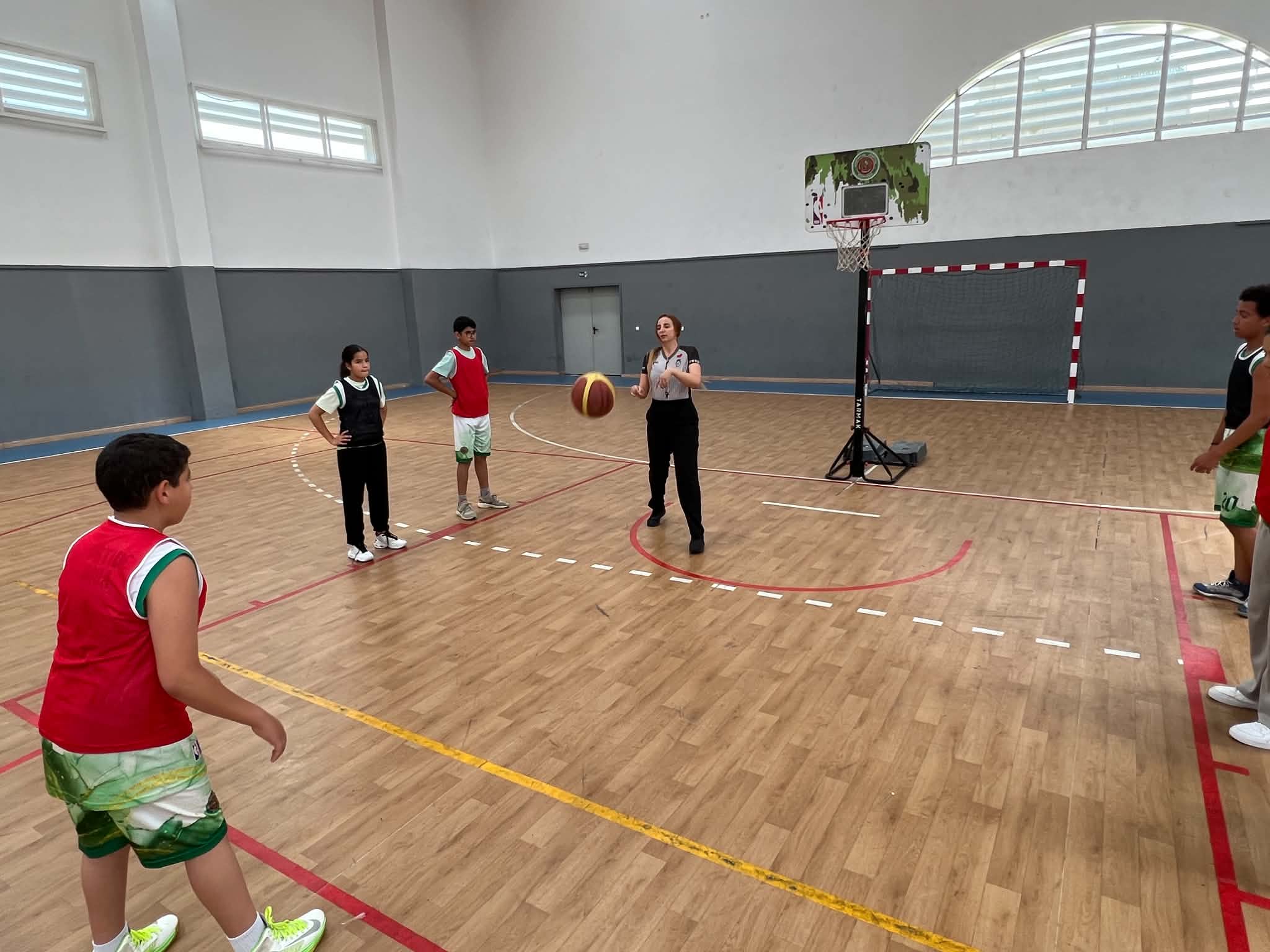 Entre-deux arbitré au coup d'envoi d'un match pour enfants dans la salle couverte